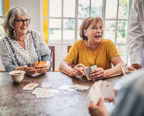 older adults playing cards while drinking coffee