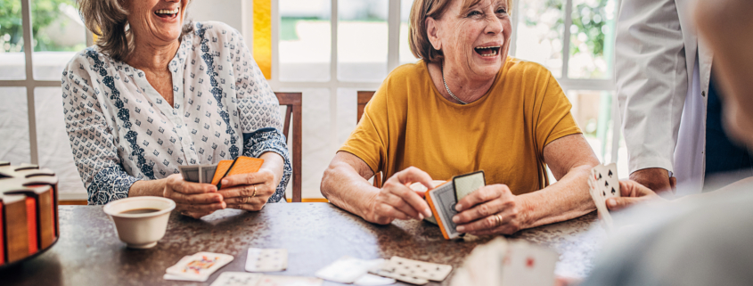 older adults playing cards while drinking coffee